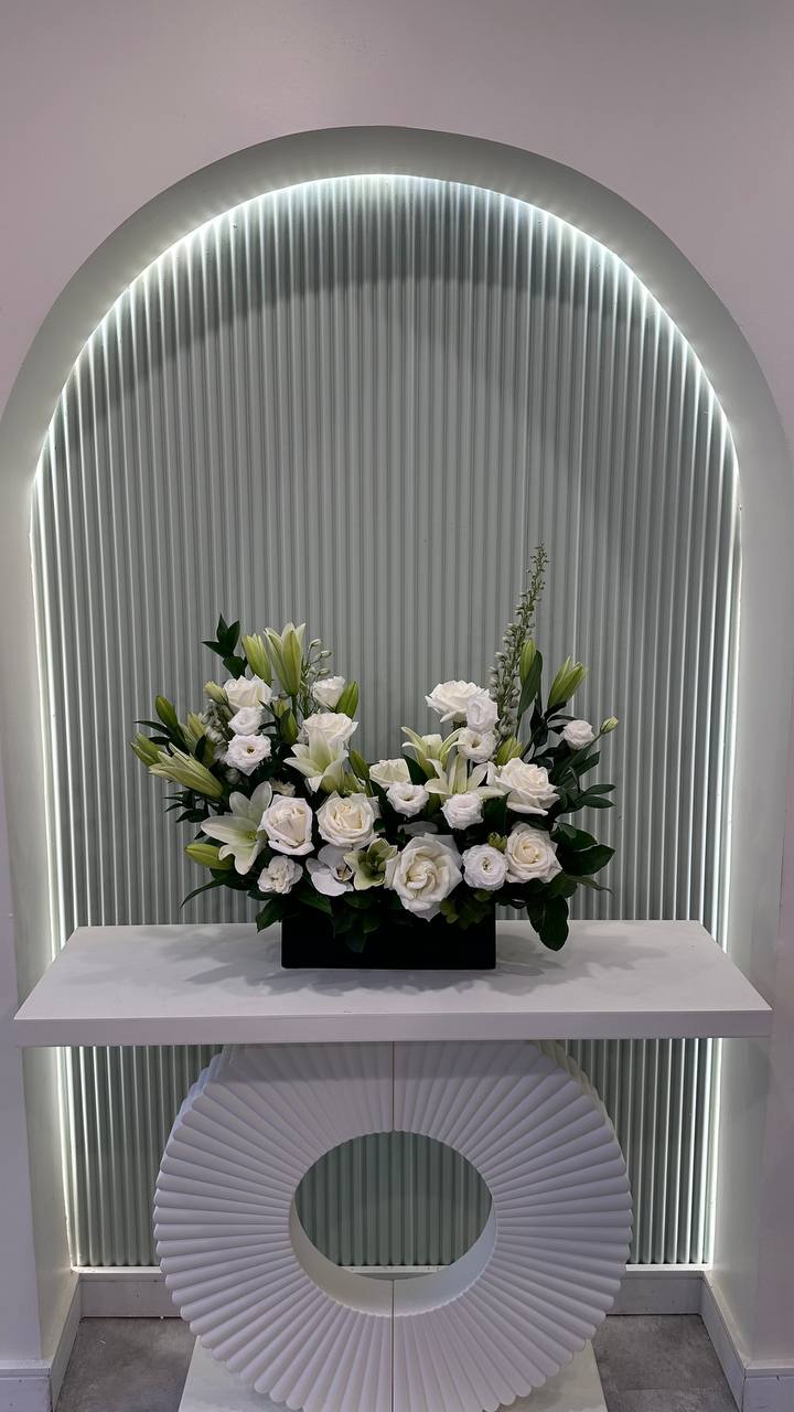 Sophisticated white rose and lily arrangement on luxury display ,gifts, décor or sympathy occasions