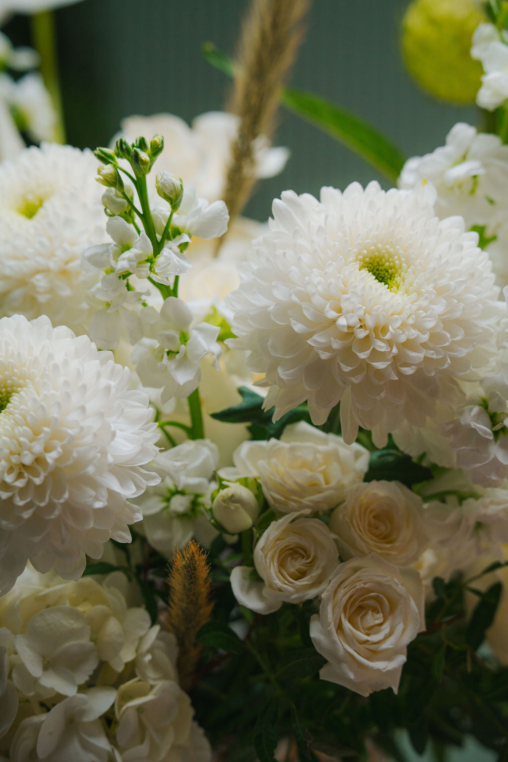 Luxury white floral basket with anthurium, roses, and textured greenery in a woven basket