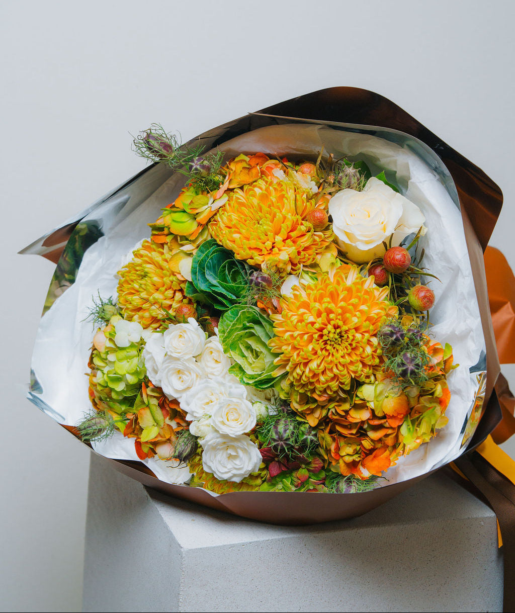Luxury autumn bouquet with golden chrysanthemums, ivory roses, and brown wrapping by Lotus Land