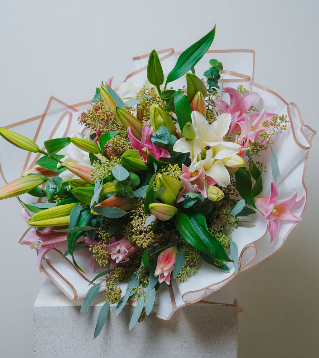 Luxury pink and white lily bouquet with eucalyptus and elegant wrapping by Lotus Land