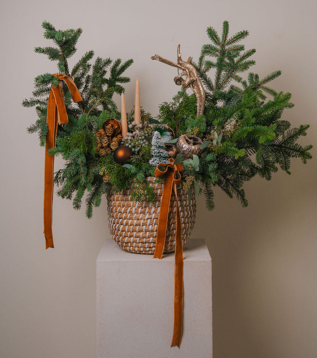 Luxury evergreen Christmas arrangement with natural greenery, golden accents, and forest-inspired design