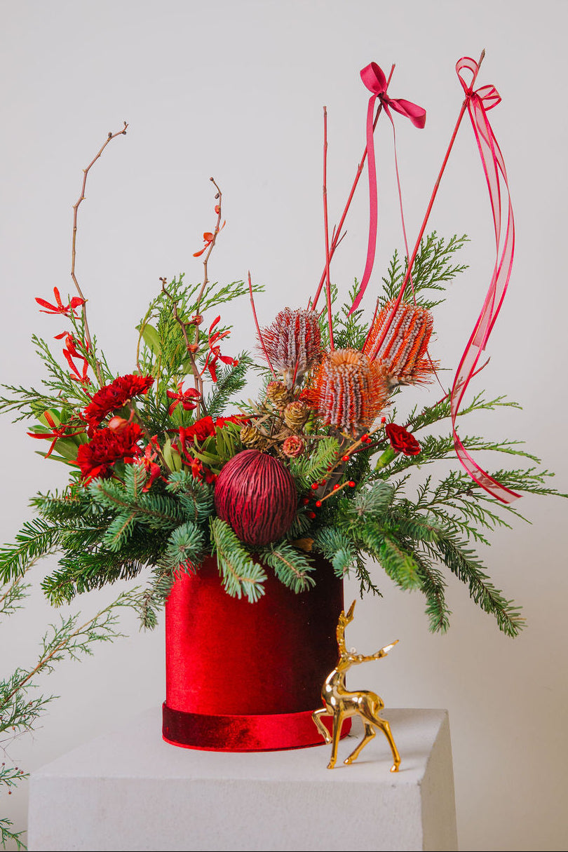 Luxury Christmas floral arrangement with evergreen and crimson accents