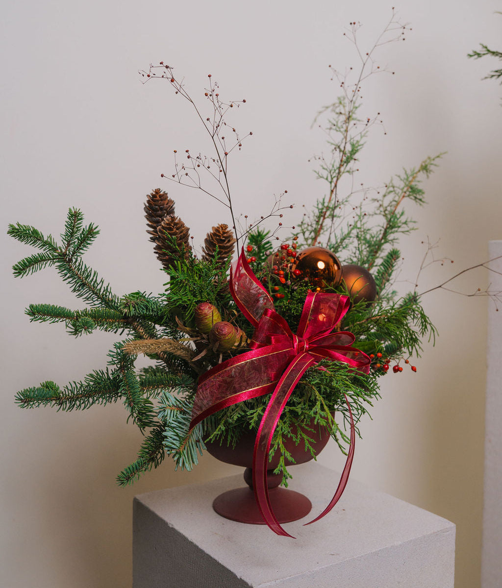 Red and green Christmas floral décor with fresh evergreens and pine