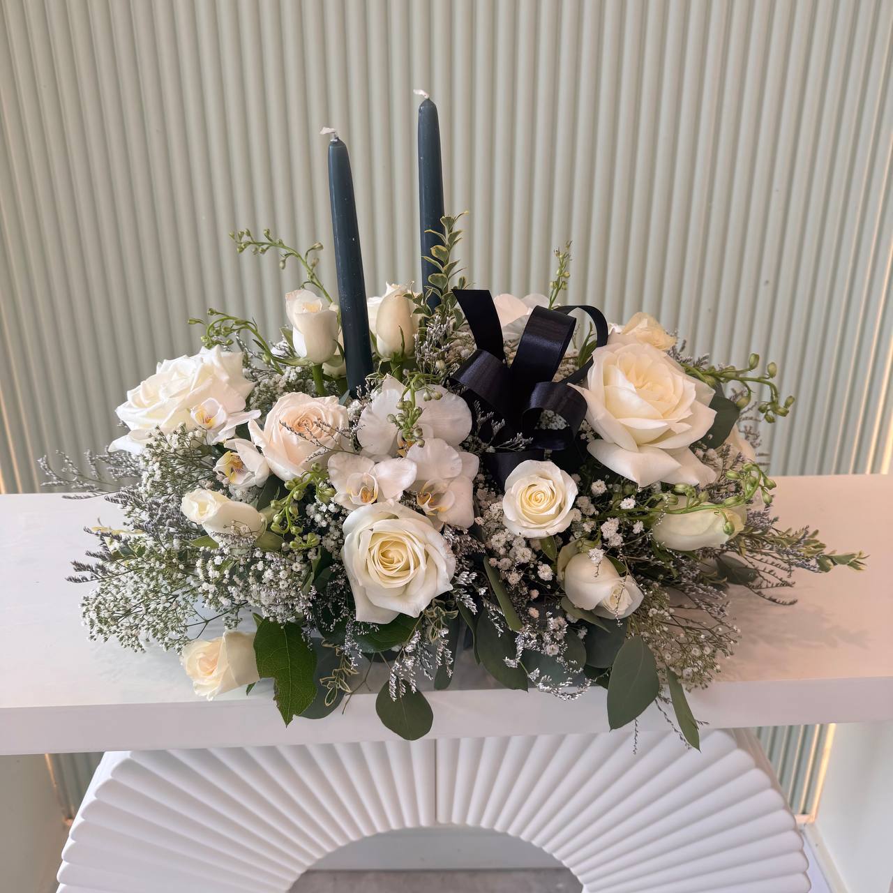 Elegant white floral tribute with candles and baby’s breath – available in GTA