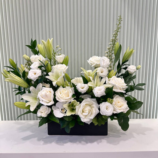 Elegant white flower arrangement with roses, lilies in a modern black vase – Aurora 