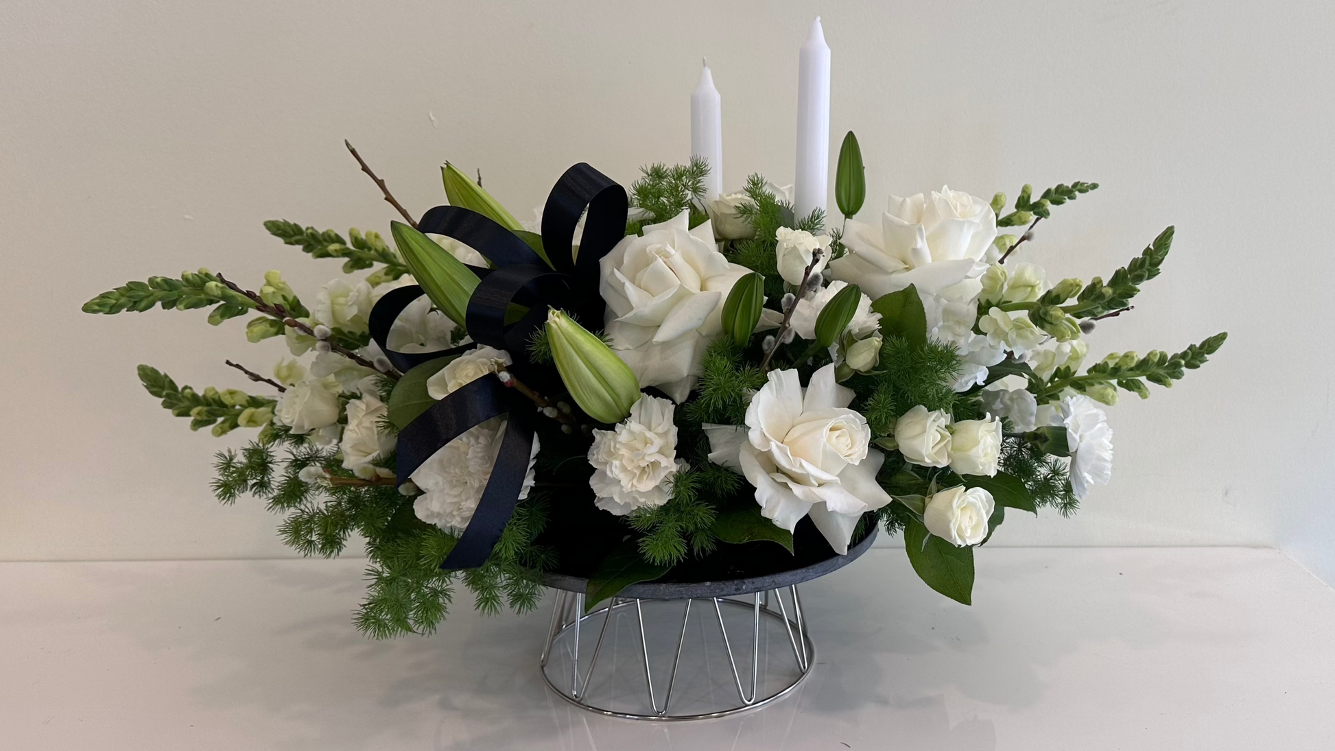 White rose sympathy flower arrangement with candles and black ribbon – Aurora florist- free delivery in Aurora

